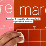 Close up of February and March pages of the rainbow wall calendar with the graphic "Erasable & reusable when used with liquid chalk markers."