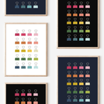 Framed art prints featuring minimalist illustrations of Binder Clips in rainbow hues on black, navy blue and white backgrounds.