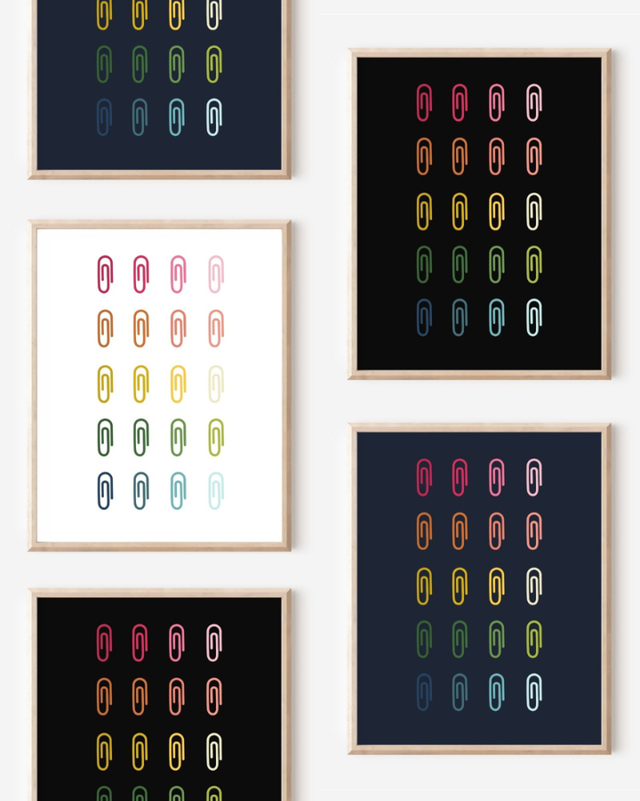 Framed art prints featuring minimalist illustrations of Paper Clips in rainbow hues on black, navy blue and white backgrounds.