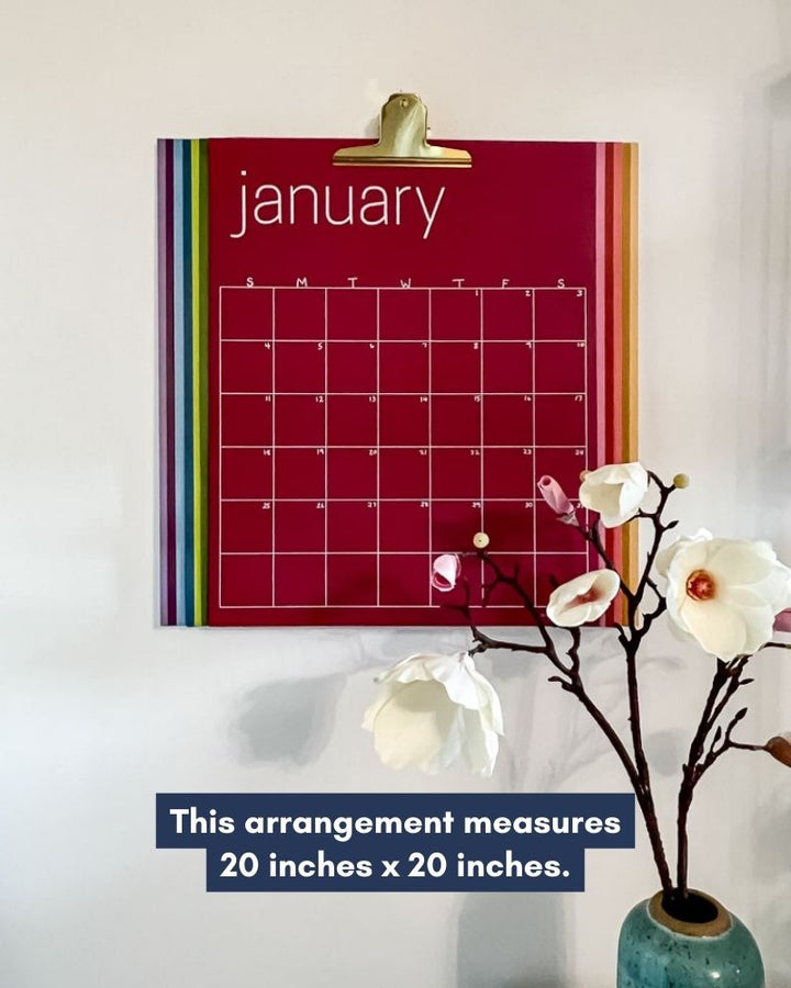 photo of large reusable rainbow calendar hanging with large brass clip
