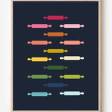 Kitchen wall art featuring rolling pins in ombre rainbow hues arranged in a grid pattern on a blue background.