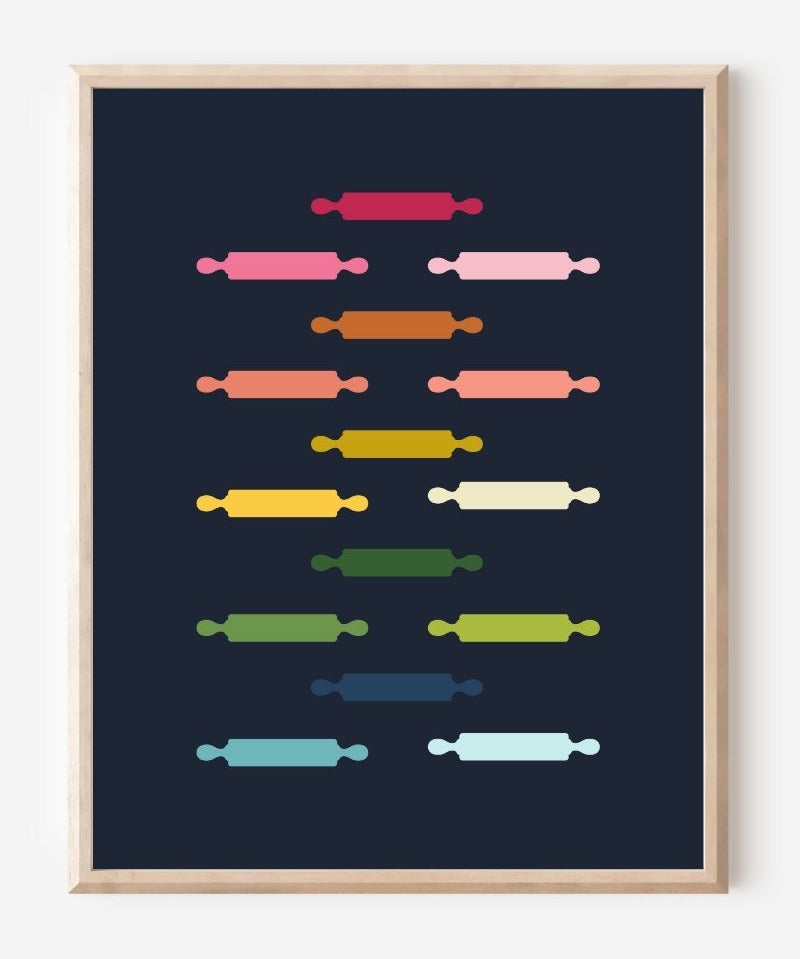 Kitchen wall art featuring rolling pins in ombre rainbow hues arranged in a grid pattern on a blue background.