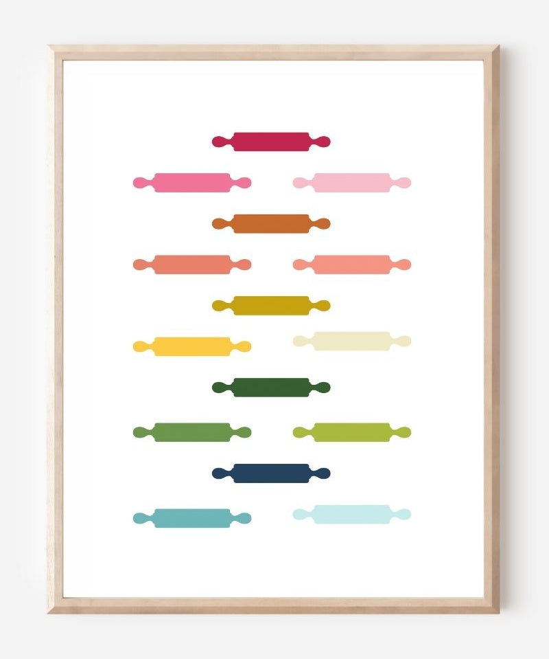 Kitchen wall art featuring rolling pins in ombre rainbow hues arranged in a grid pattern on a white background.