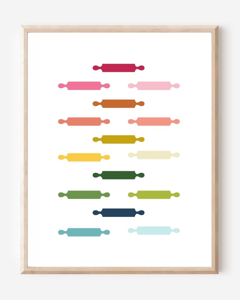 Kitchen wall art featuring rolling pins in ombre rainbow hues arranged in a grid pattern on a white background.