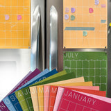colorful monthly calendar in rainbow hues hanging on refrigerator