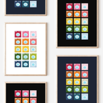 Framed art prints featuring minimalist illustrations of Washing Machines in rainbow hues on black, navy blue and white backgrounds.