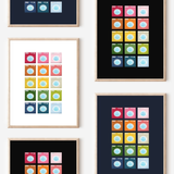 Framed art prints featuring minimalist illustrations of Washing Machines in rainbow hues on black, navy blue and white backgrounds.