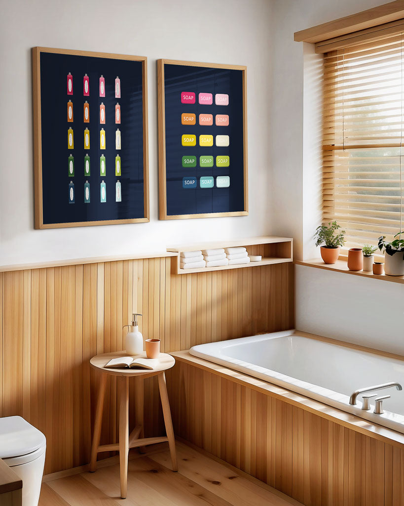 A set of navy bathroom themed digital art prints featuring colorful soaps and Toothpaste images, displayed on a wall above a wooden bathroom tub and next to a toilet.