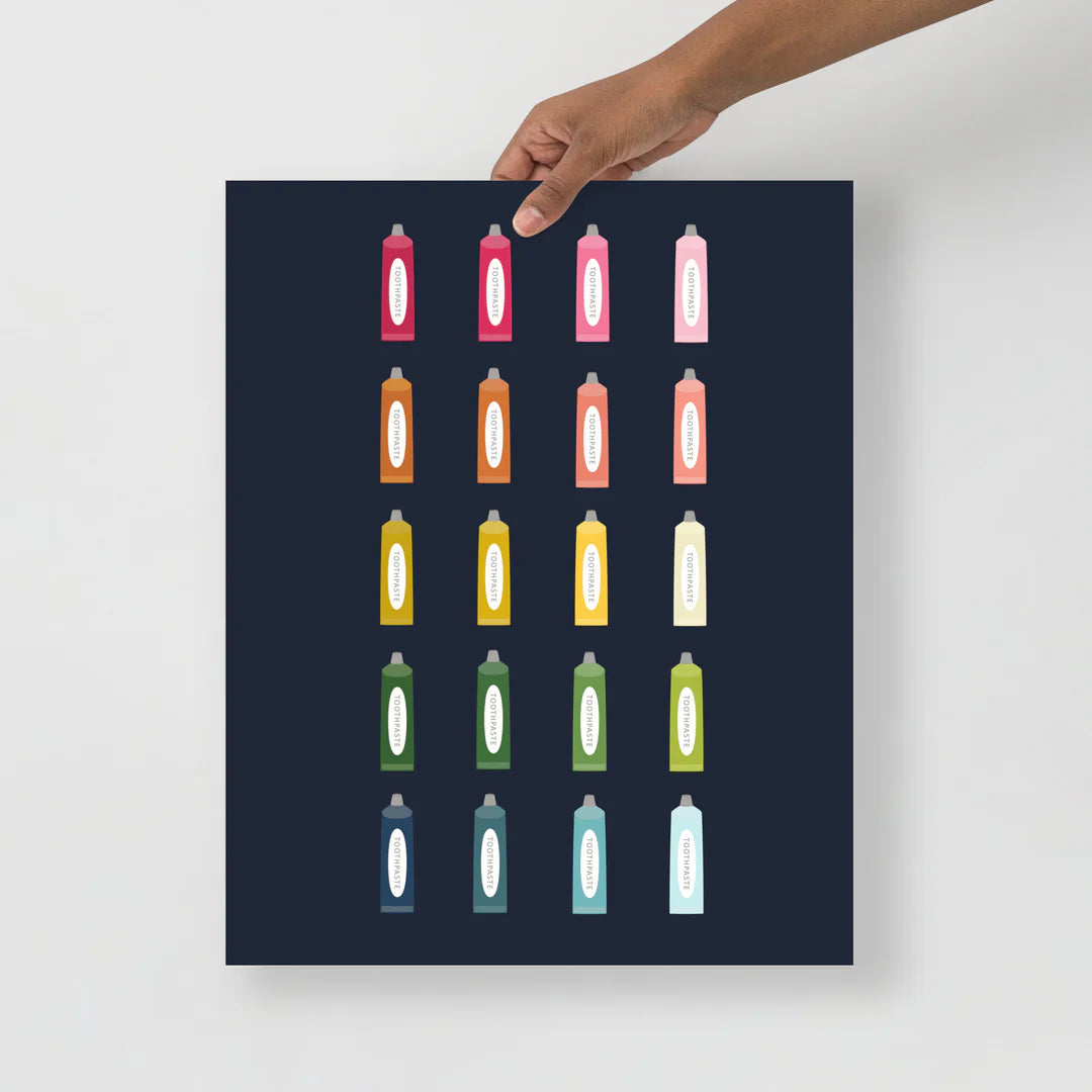 bathroom art print with a navy background and grid of colorful clip art of toothpaste tubes in ombre rainbow colors ranging from pinks to blues