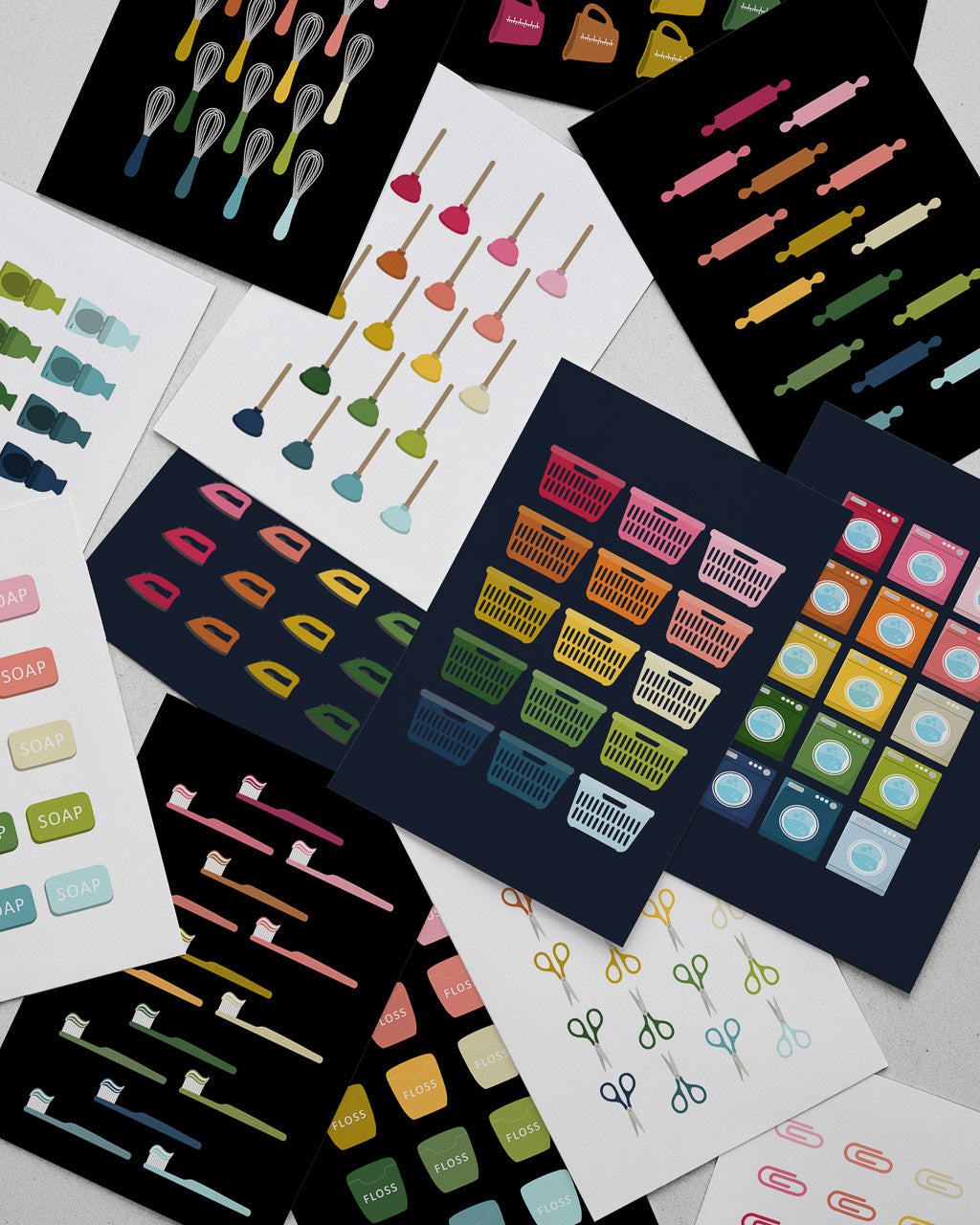stack of rainbow graphic art prints featuring everyday objects like laundry baskets, toilet plungers, toothbrushes and scissors laid on a light gray surface
