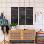 Room interior with a wooden sideboard, large black calendar on the wall, colorful basket and coat rack