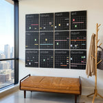 Large black wall calendar displayed with a modern interior setting featuring a leather bench and coat rack