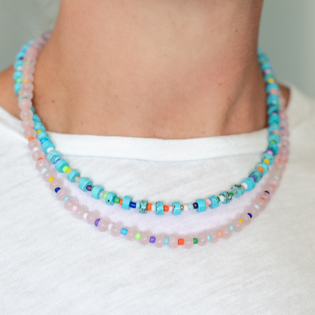 Two small beaded necklaces in soft pink and blues with rainbow bead accents.