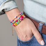 Stacked colorful bracelets with gold chain accents by Kaleidoscope Living.