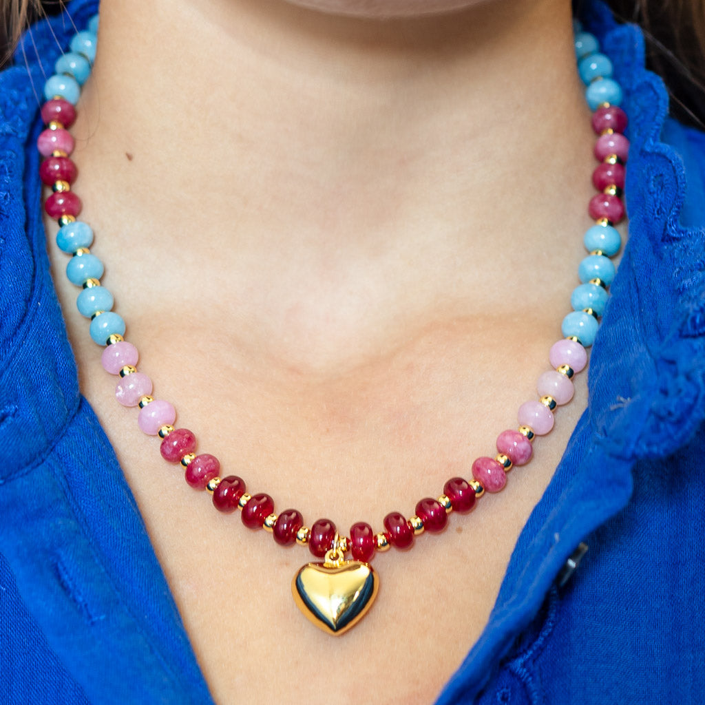 A necklace in a blend of pink, blue, and yellow natural stone beads accented with a gold heart pendant by Kaleidoscope Living.