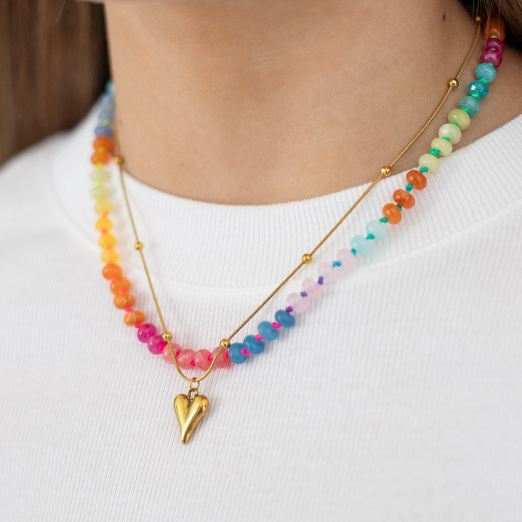 Colorful statement beaded necklace with a neon color changing cord paired with a gold heart pendant