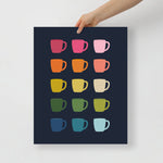 kitchen art print with a navy background and grid of colorful clip art of coffee mugs in ombre rainbow colors ranging from pinks to blues