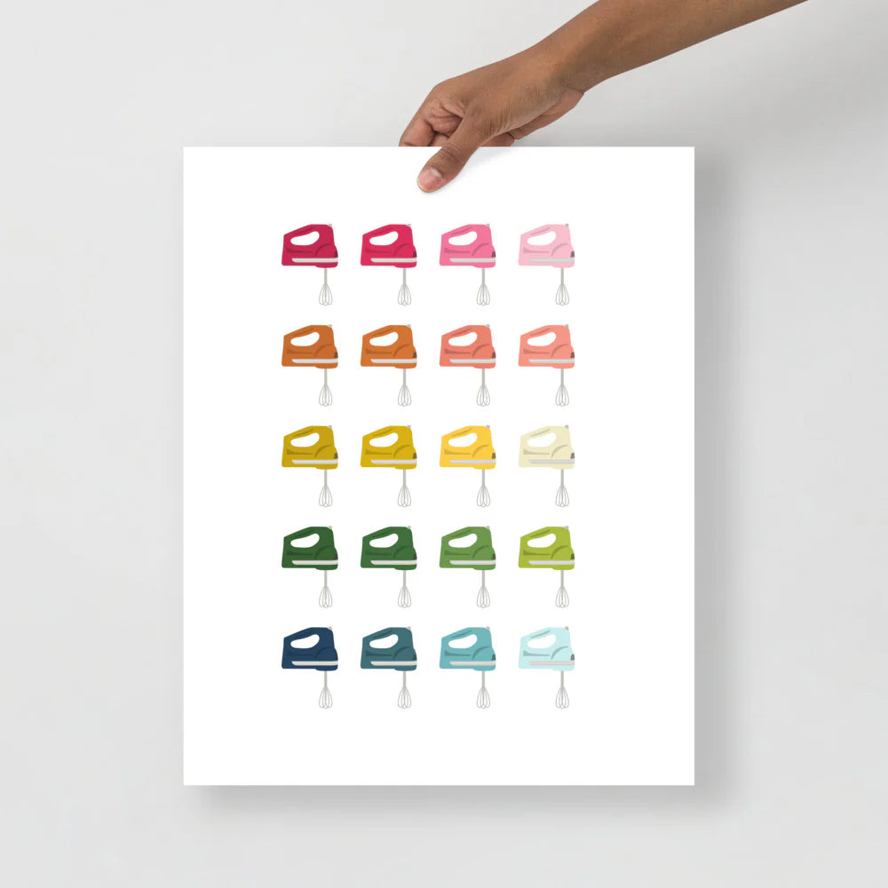 kitchen art print with a white background and grid of colorful clip art of hand mixers in ombre rainbow colors ranging from pinks to blues