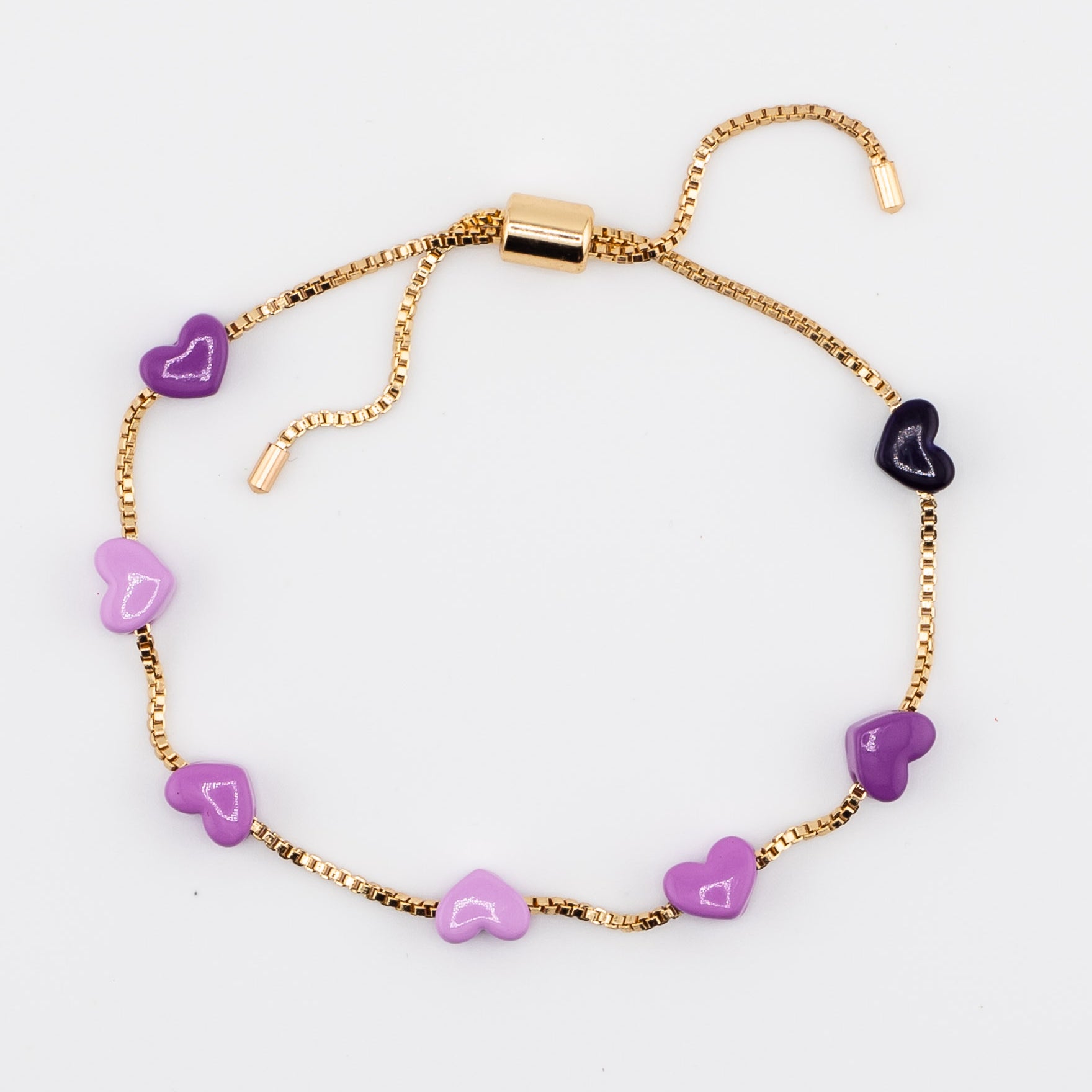 Gold adjustable bracelet with purple enamel hearts on a white background