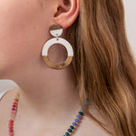 Close-up of a girl wearing wood and white resin hoop earring with a colorful beaded necklace by Kaleidoscope Living