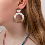 Close-up of a girl wearing wood and white resin hoop earring with a colorful beaded necklace by Kaleidoscope Living