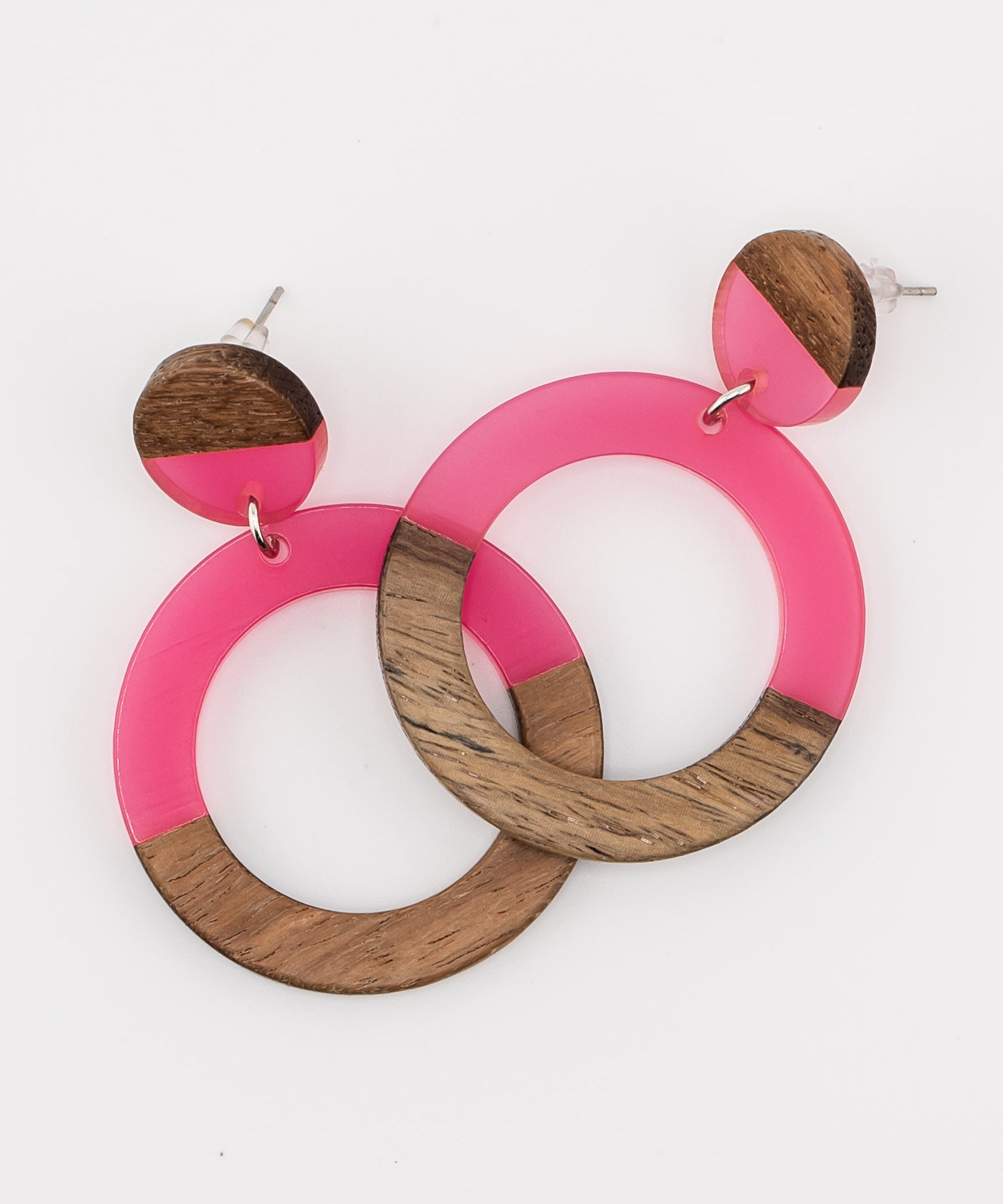 Pair of pink resin and wood circle earrings on a white background 