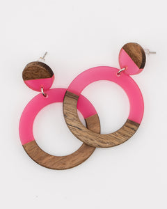 Pair of pink resin and wood circle earrings on a white background 