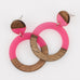 Pair of pink resin and wood circle earrings on a white background 