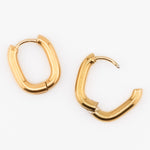 Gold oval hoop earrings on a white background
