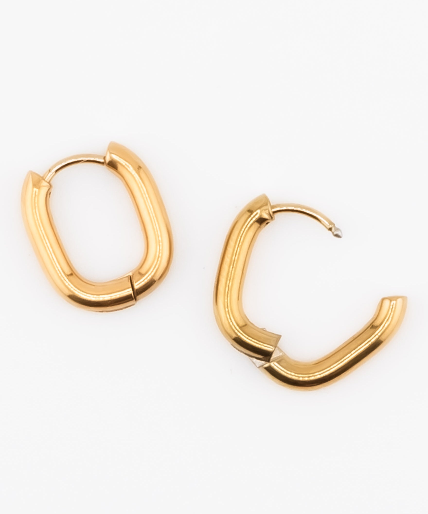 Gold oval hoop earrings on a white background