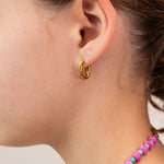 Close up picture of a gold hoop oval earring by Kaleidoscope Living.