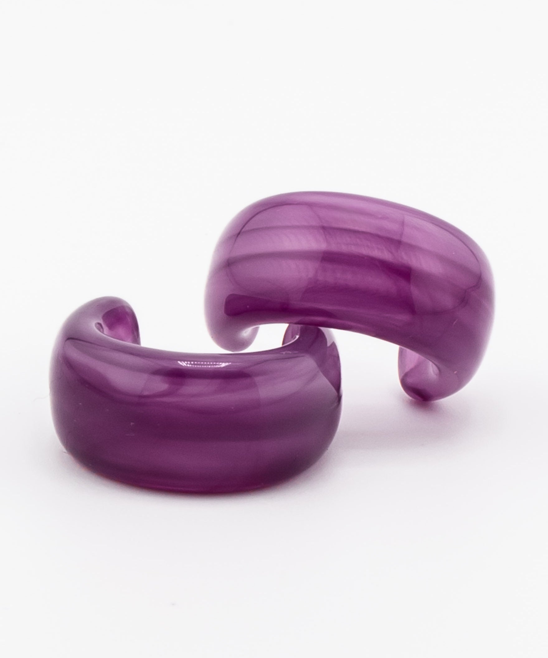 Pair of purple acrylic hoop earrings on a white background