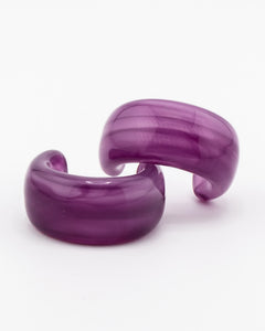 Pair of purple acrylic hoop earrings on a white background