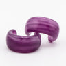 Pair of purple acrylic hoop earrings on a white background