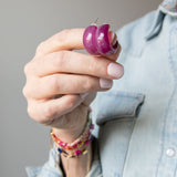 Hand holding a set of purple acrylic earrings by Kaleidoscope Living