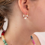 Close up of girl with heart shaped huggie in white, pink and red tones