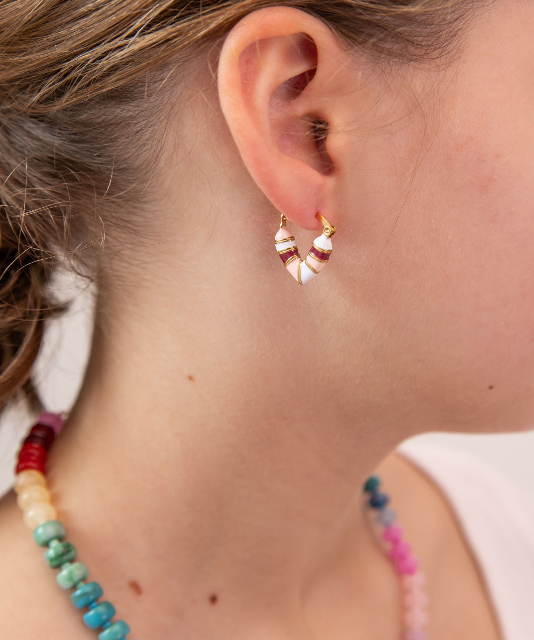 Close up of girl with heart shaped huggie in white, pink and red tones