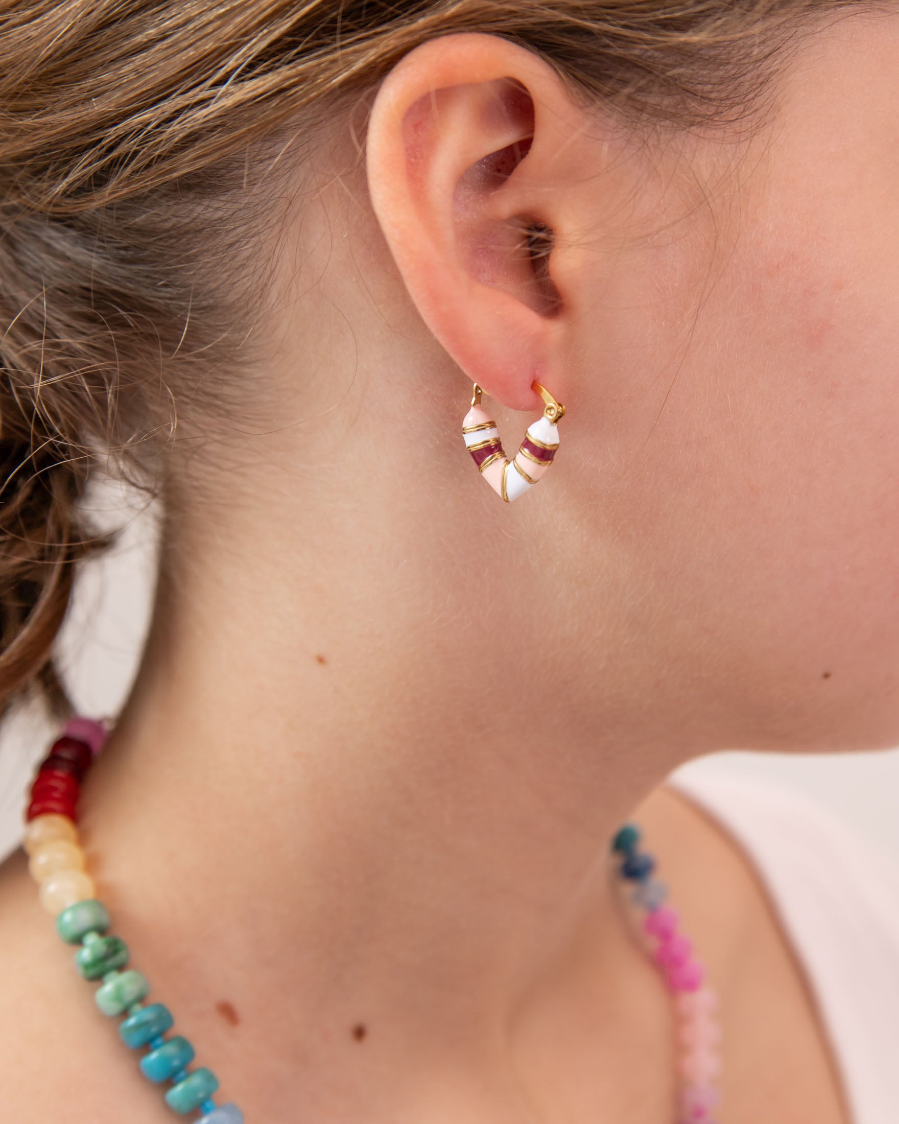 Close up of girl with heart shaped huggie in white, pink and red tones