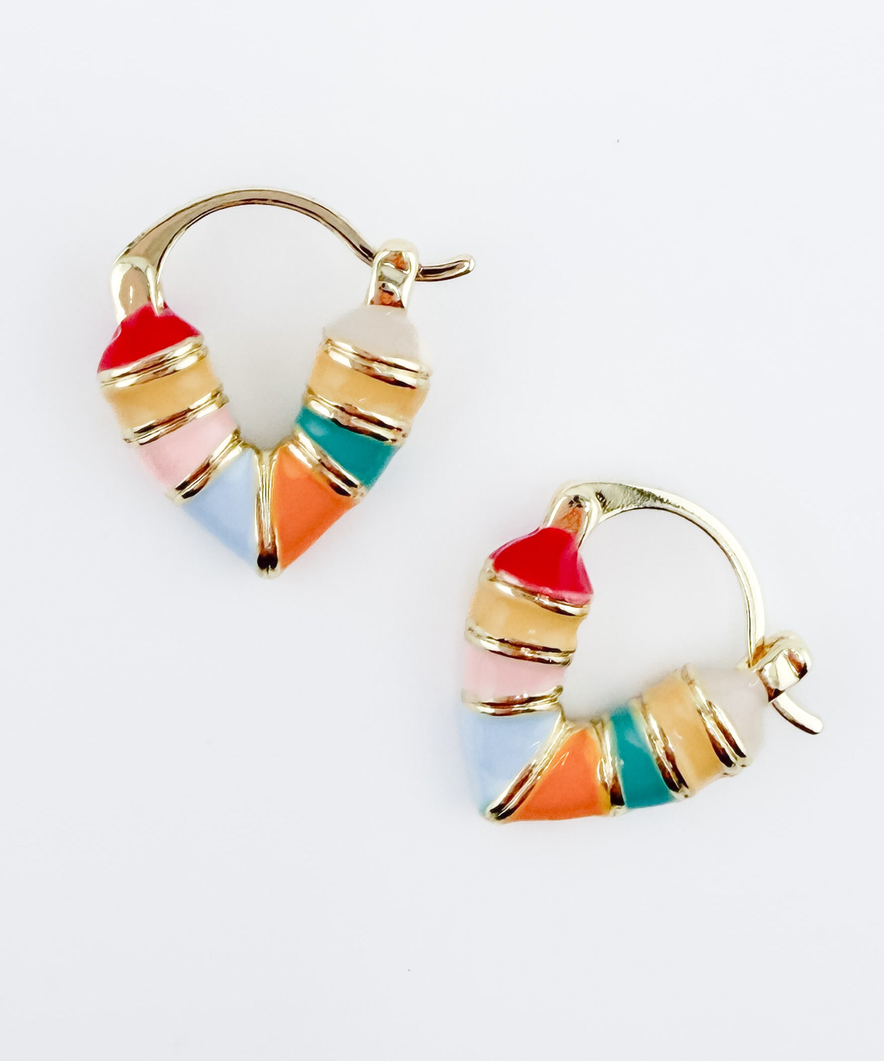 Gold heart-shaped huggie hoop earrings with multicolor enamel detailing in shades of pink, blue, orange, yellow and teal.