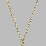 A gold paperclip chain necklace with a small gold cross pendant, displayed against a solid gray background.