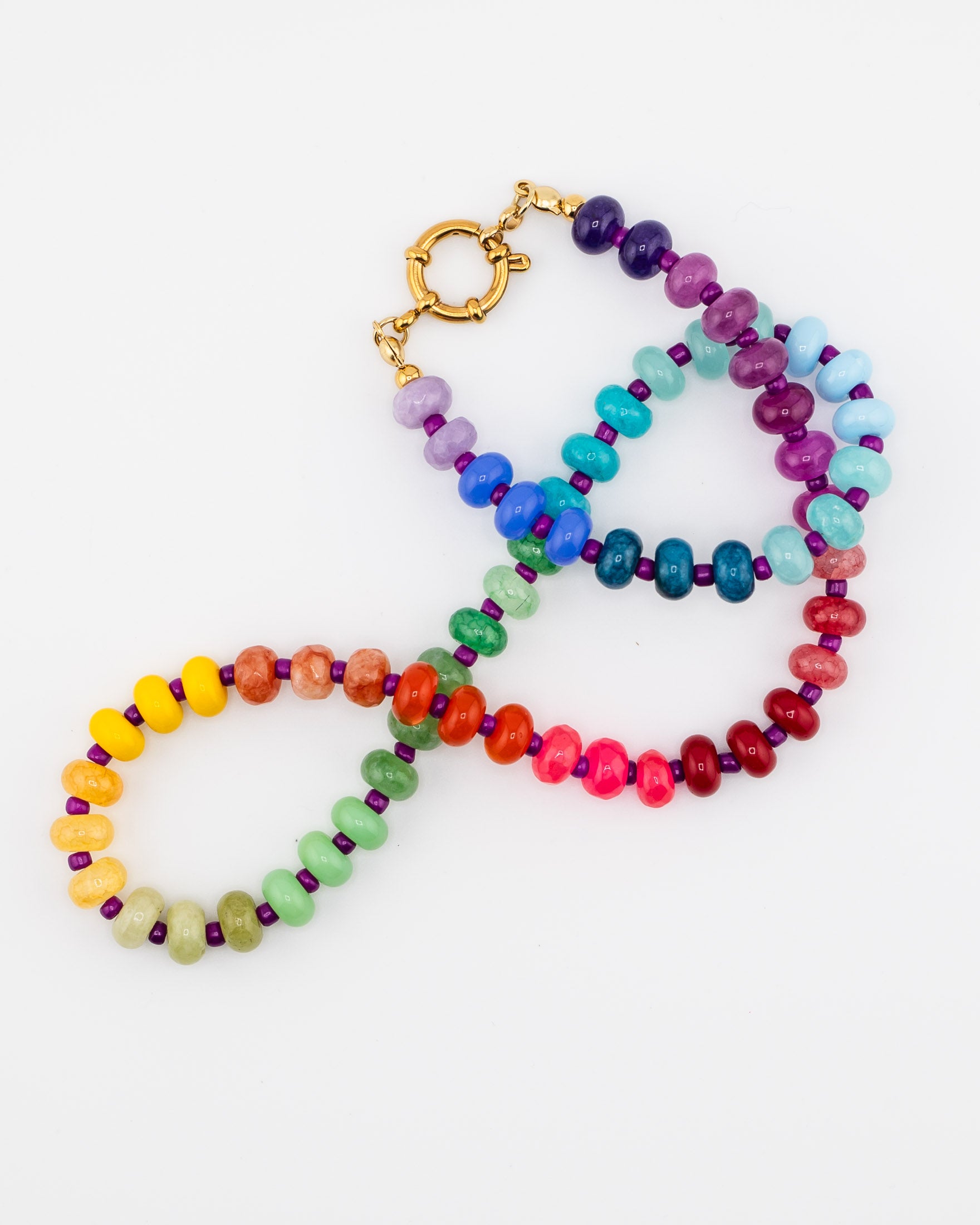 Colorful beaded necklace with gold clasp lying on a white table