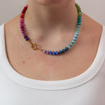 Rainbow gradient beaded necklace worn by a women showing the gold clasp worn to the side