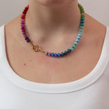 Rainbow gradient beaded necklace worn by a women showing the gold clasp worn to the side