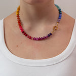 Rainbow gradient beaded necklace on a women wearing a white t-shirt showing the gold clasp to the side.