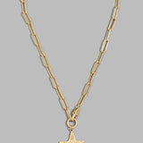 A gold paperclip chain necklace with a textured star-shaped pendant, displayed against a solid gray background.