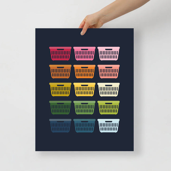 laundry room art print with a navy background and grid of colorful clip art of laundry baskets in ombre rainbow colors ranging from pinks to blues