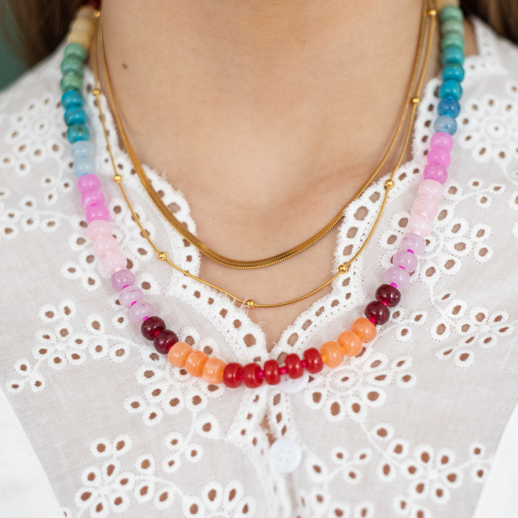 Layered gold necklace paired with colorful beaded necklace by Kaleidoscope Living.