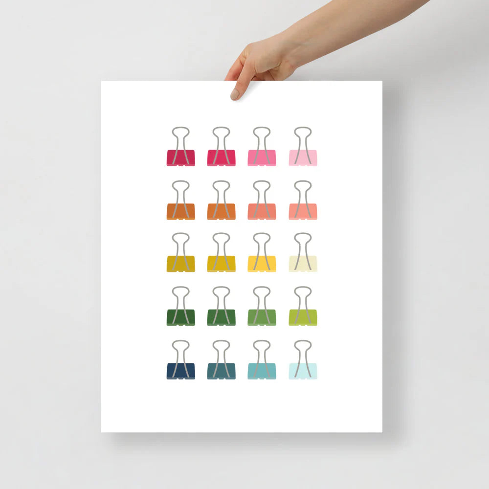 office art print with a white background and grid of colorful clip art of binder clips in ombre rainbow colors ranging from pinks to blues