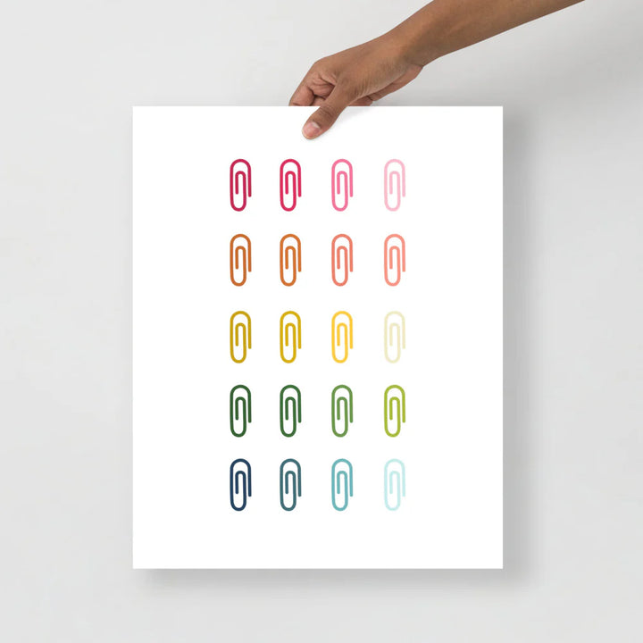 office art print with a white background and grid of colorful clip art of paperclips in ombre rainbow colors ranging from pinks to blues