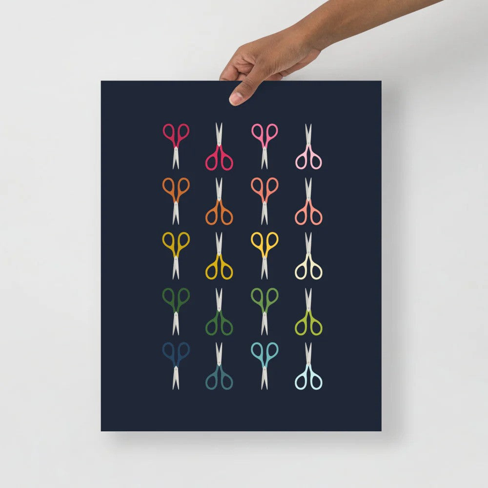 office art print with a navy background and grid of colorful clip art of scissors in ombre rainbow colors ranging from pinks to blues